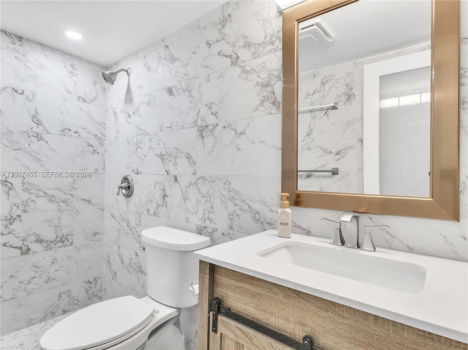 6505 Southwest 113th Place Miami, FL 33173 - Photo 9 of 25 a bathroom with a sink a toilet and a mirror