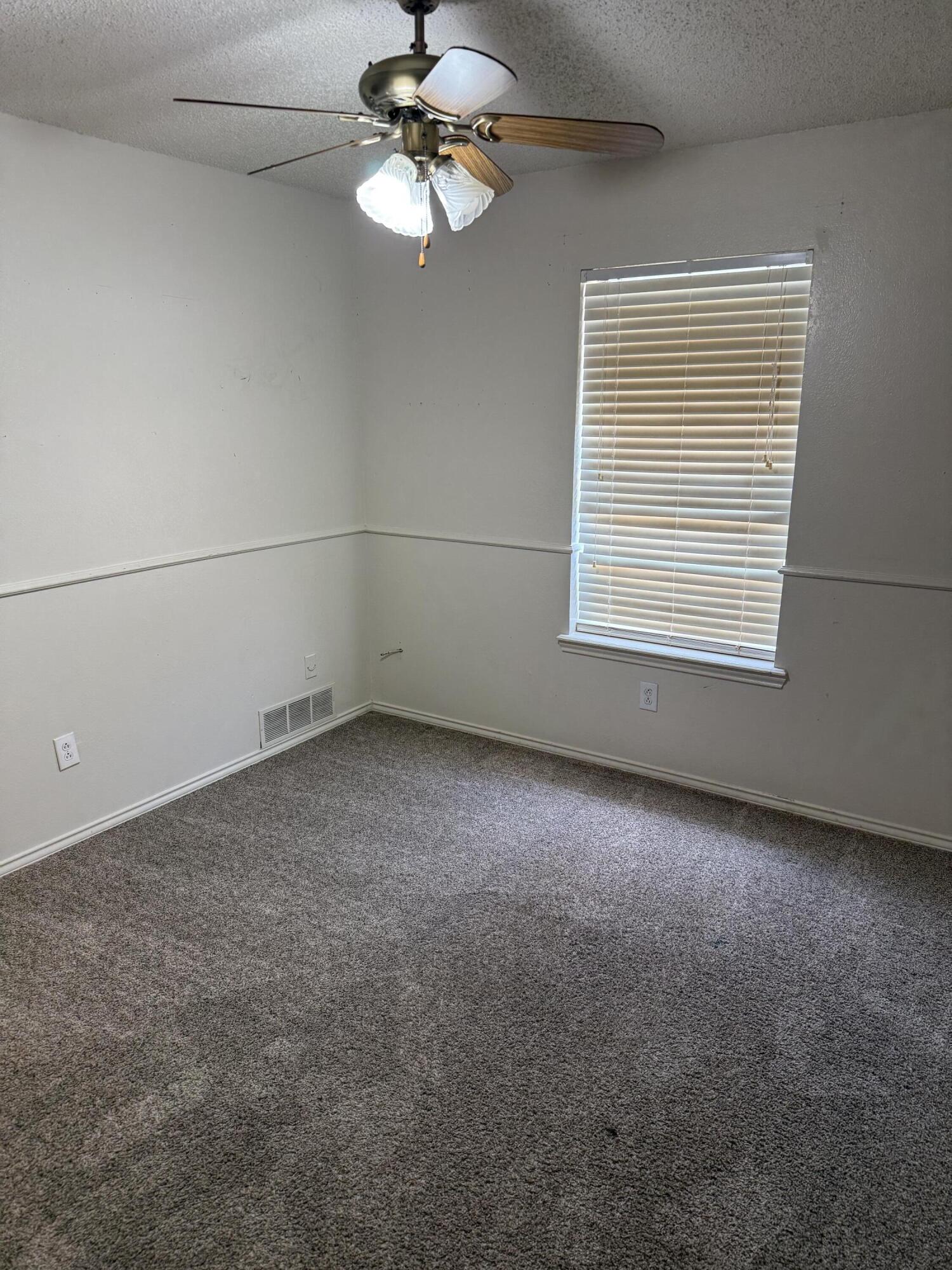 6004 68th Street Lubbock, TX 79424 - Photo 11 of 17 an empty room with a empty space and a ceiling fan