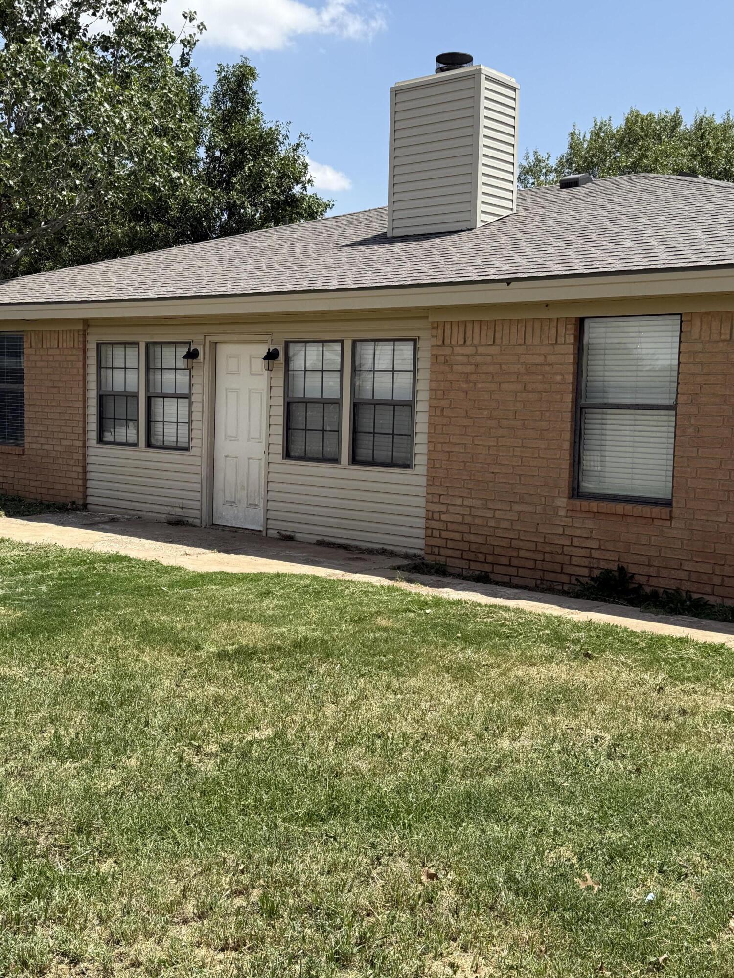 6004 68th Street Lubbock, TX 79424 - Photo 15 of 17 a front view of a house with a yard