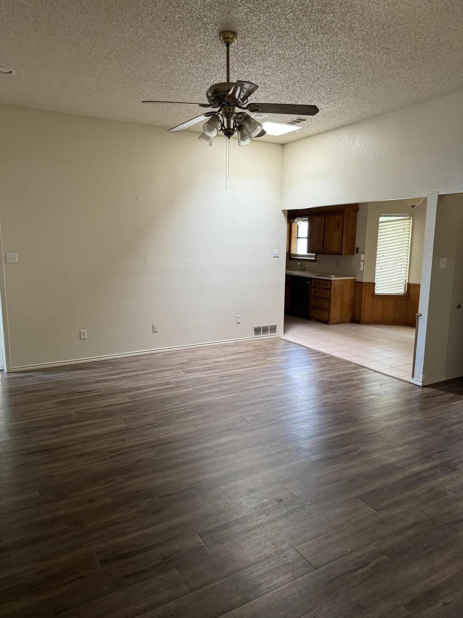 6004 68th Street Lubbock, TX 79424 - Photo 5 of 17 wooden floor in an empty room with a window