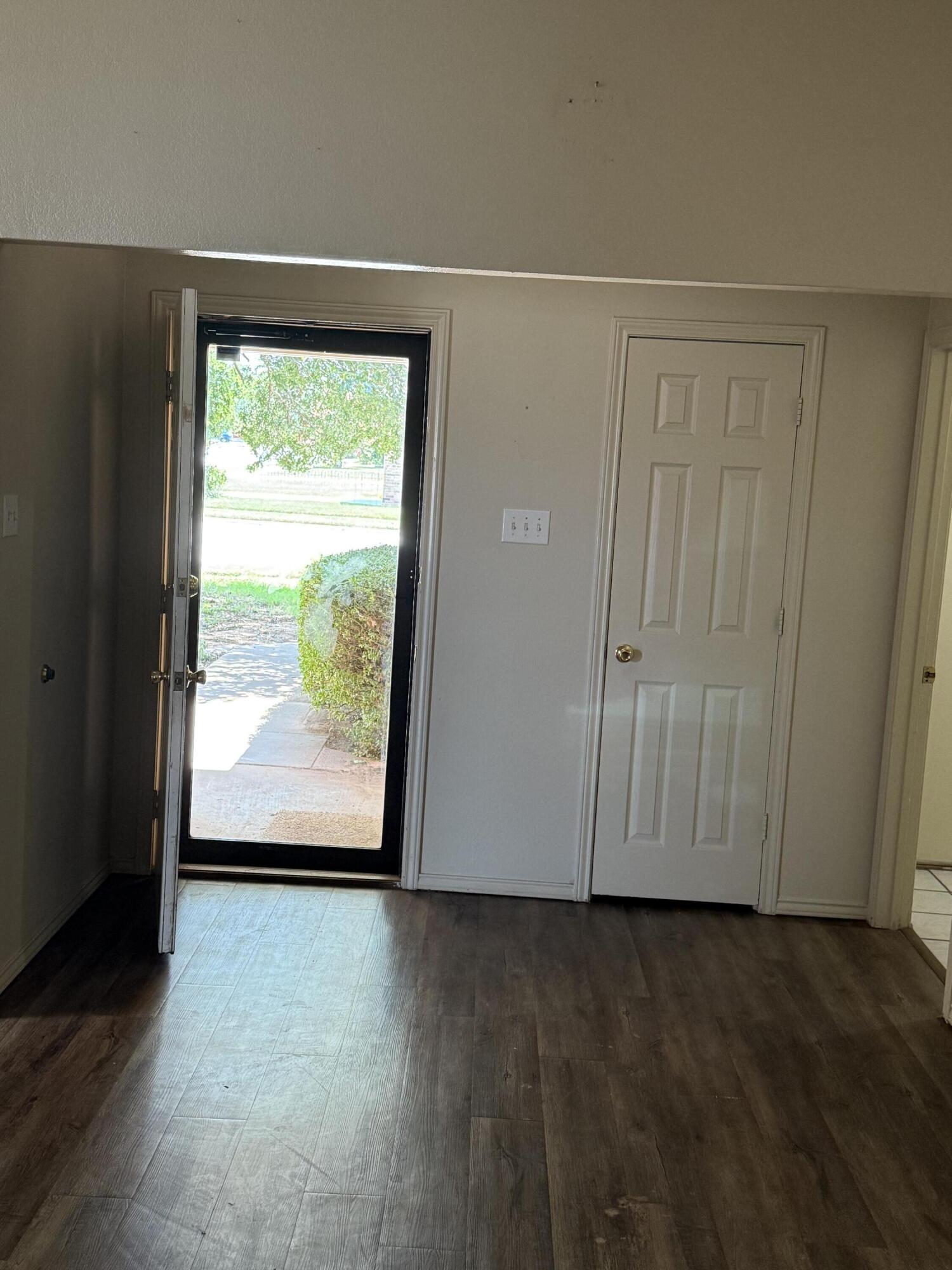 6004 68th Street Lubbock, TX 79424 - Photo 6 of 17 an empty room with wooden floor and windows