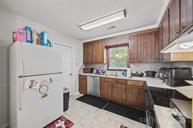 a kitchen with a refrigerator a stove a sink and a cabinets