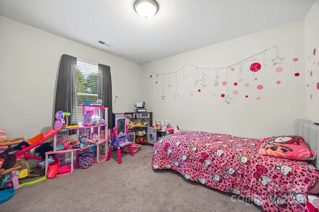 a bedroom with baby toys and a chandelier