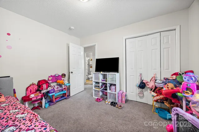 a bedroom with furniture and a flat screen tv