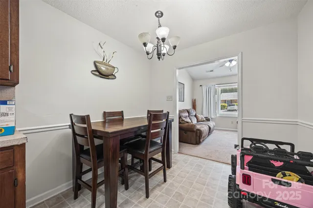 a view of a dining room with furniture a chandelier and wooden floor