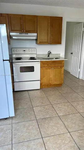 a kitchen with a stove top oven and cabinets