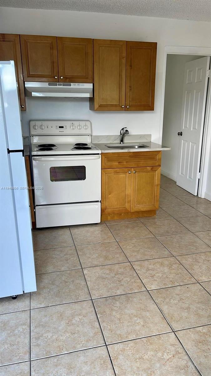 59 West 26th Street, Unit 7 Hialeah, FL 33010 - Photo 1 of 4 a kitchen with a stove top oven and cabinets