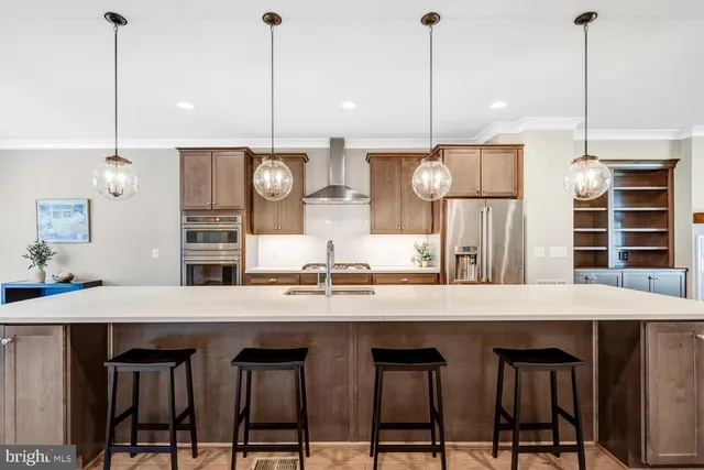 a kitchen with stainless steel appliances granite countertop a table chairs stove and refrigerator