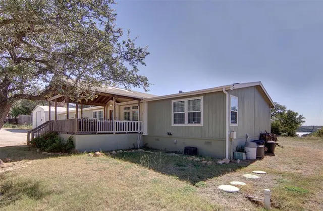 a view of a house with a yard and large tree