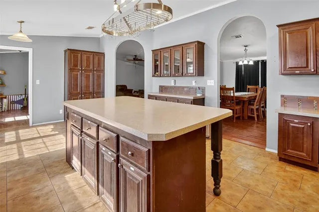 a large kitchen with kitchen island a stove a sink a dining table and chairs