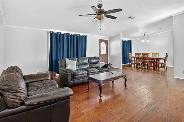 a living room with furniture ceiling fan and a wooden floor