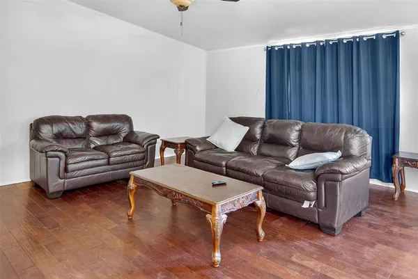a living room with furniture a wooden floor and a sink