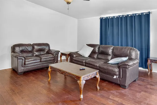 a living room with furniture a wooden floor and a sink