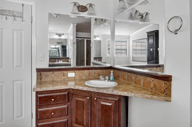 a bathroom with a granite countertop sink and a mirror