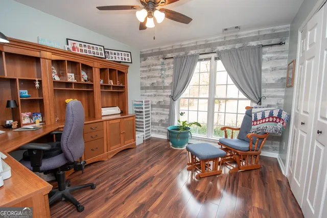 a view of a livingroom with a chandelier fan and wooden floor