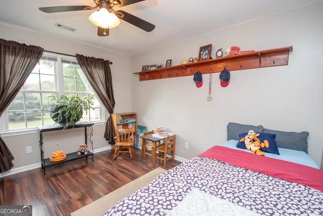 a bedroom with furniture and wooden floor