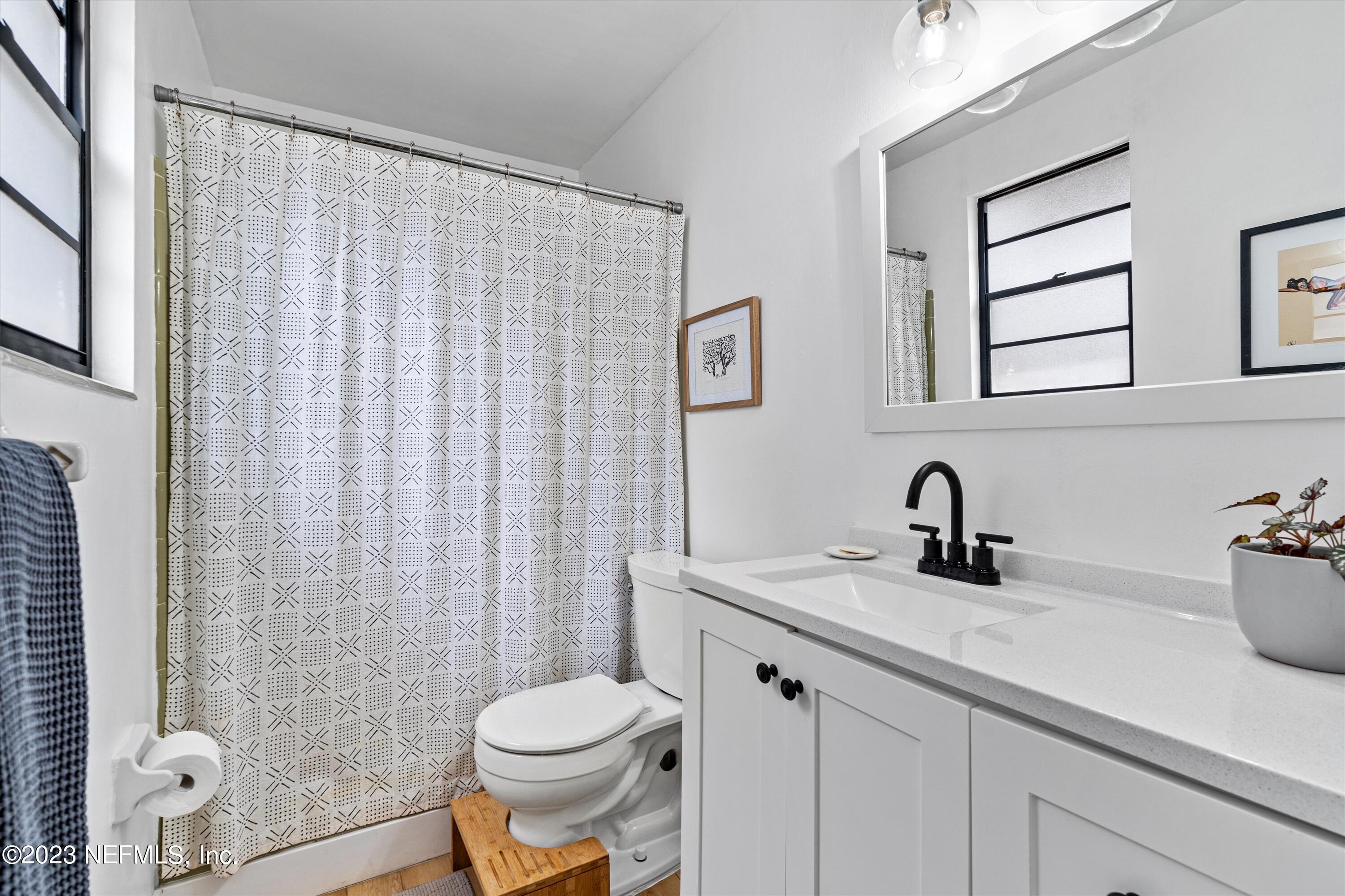 376 9th Street Atlantic Beach, FL 32233 - Photo 14 of 27 a bathroom with a sink a toilet and shower curtain
