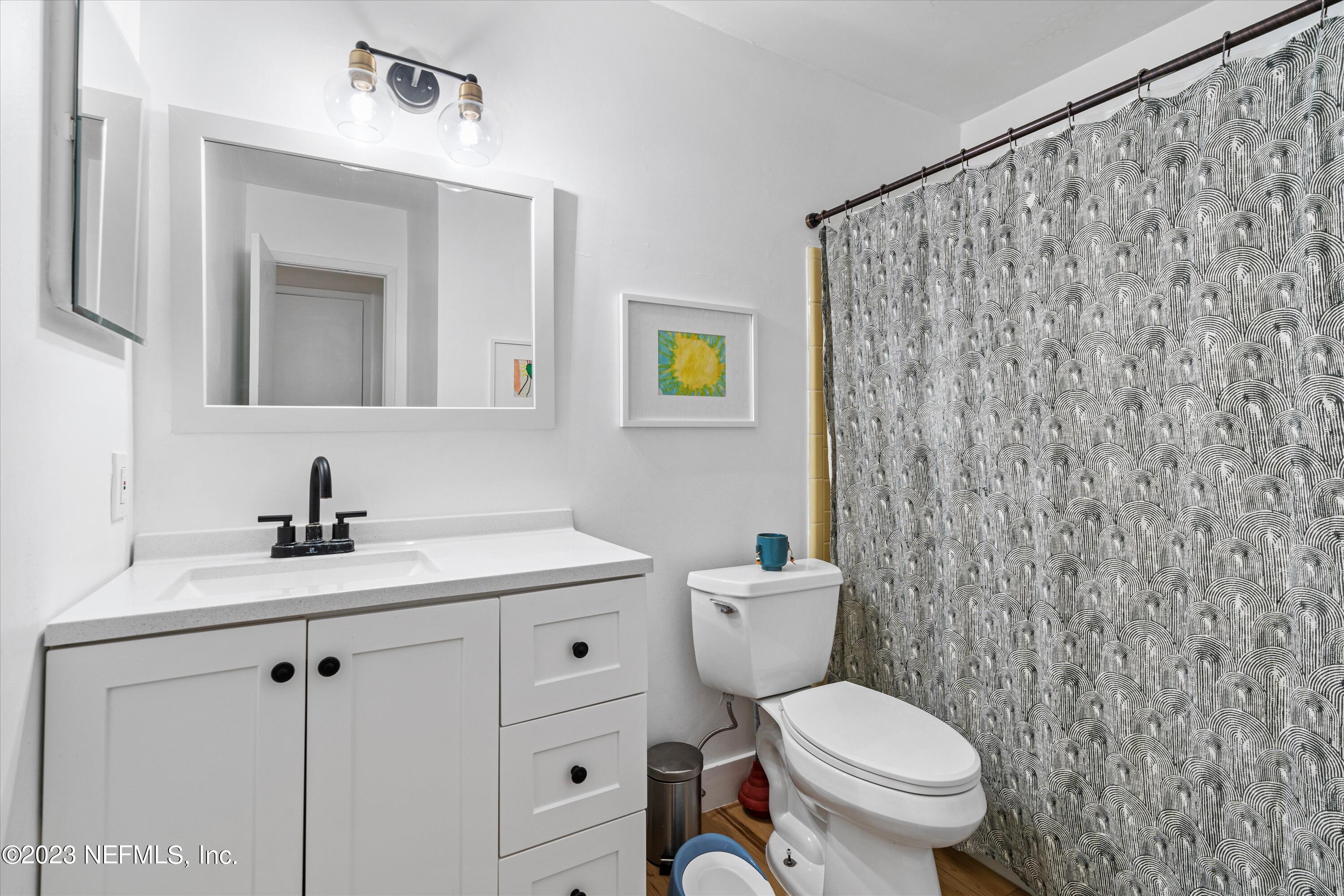 376 9th Street Atlantic Beach, FL 32233 - Photo 17 of 27 a bathroom with a toilet sink vanity and mirror