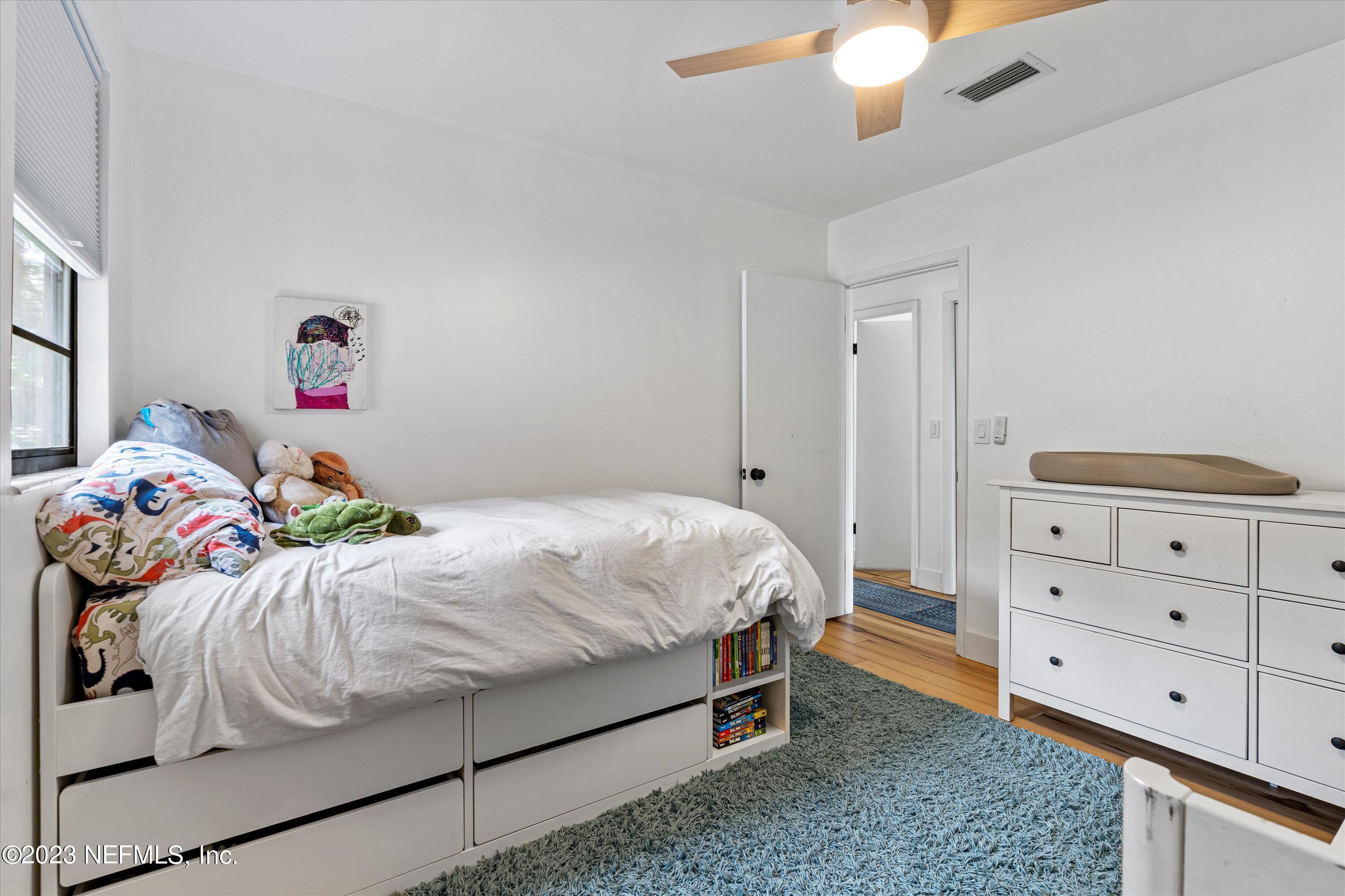 376 9th Street Atlantic Beach, FL 32233 - Photo 18 of 27 a bedroom with a bed and a chandelier