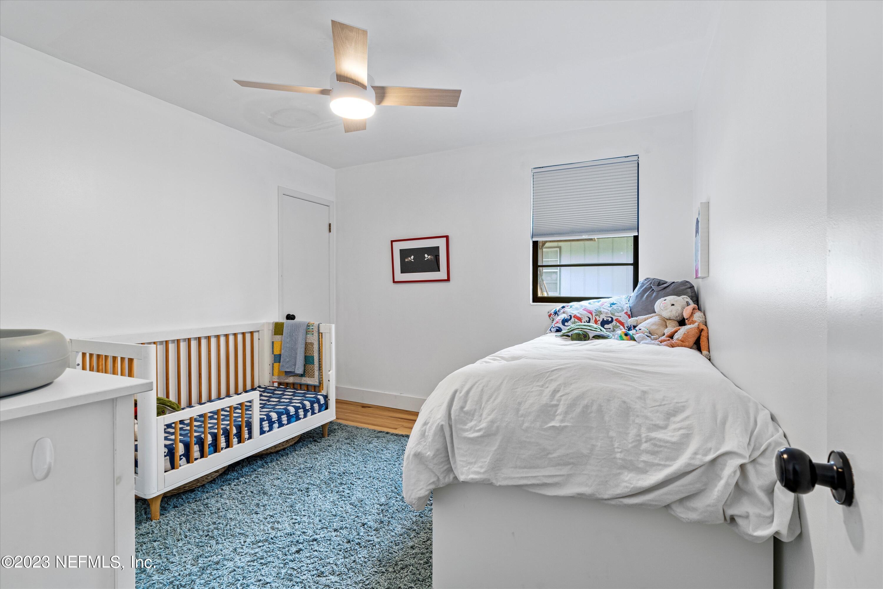 376 9th Street Atlantic Beach, FL 32233 - Photo 19 of 27 a bedroom with a bed and a chandelier