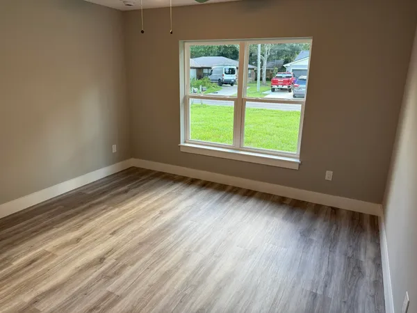 a view of room with window and wooden floor