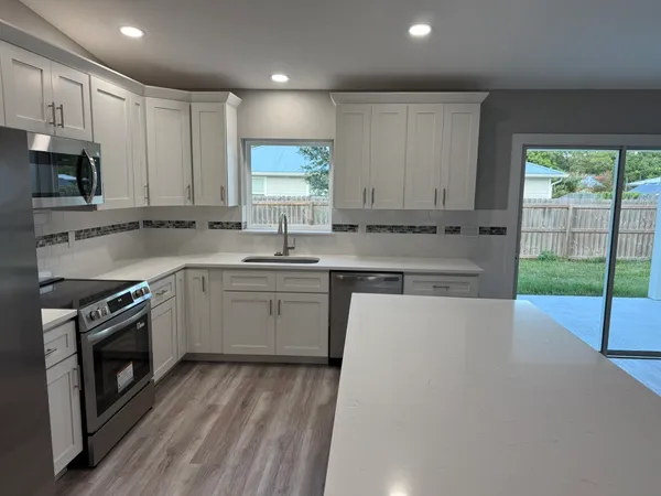 a kitchen with a sink cabinets stainless steel appliances and window