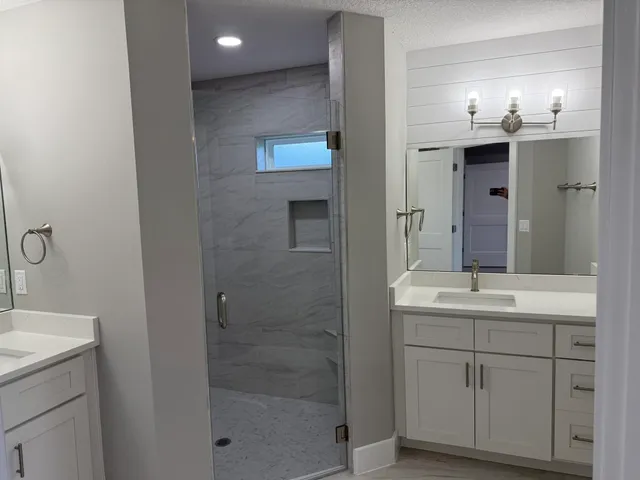 a bathroom with a shower sink and mirror