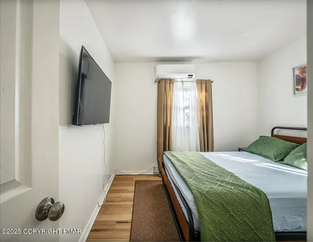 a bedroom with a bed and a flat screen tv
