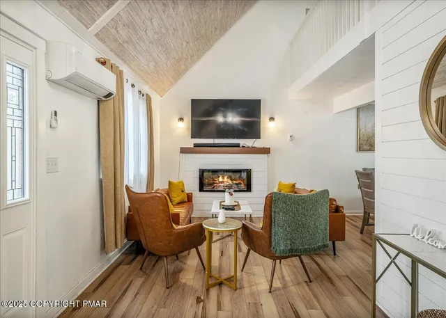 a living room with furniture a flat screen tv and a fireplace