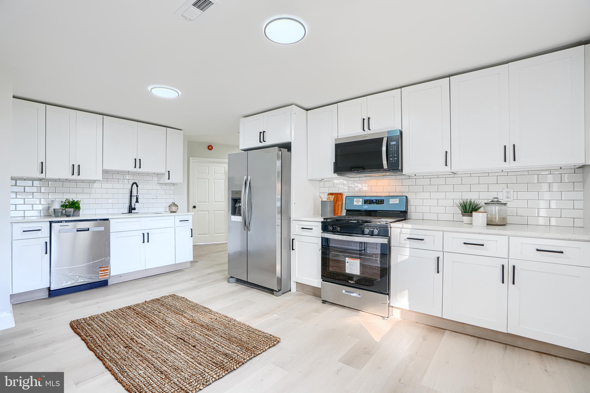 212 North Marlyn Avenue Essex, MD 21221 - Photo 19 of 54 a kitchen with stainless steel appliances white cabinets a sink a stove a refrigerator and a microwave