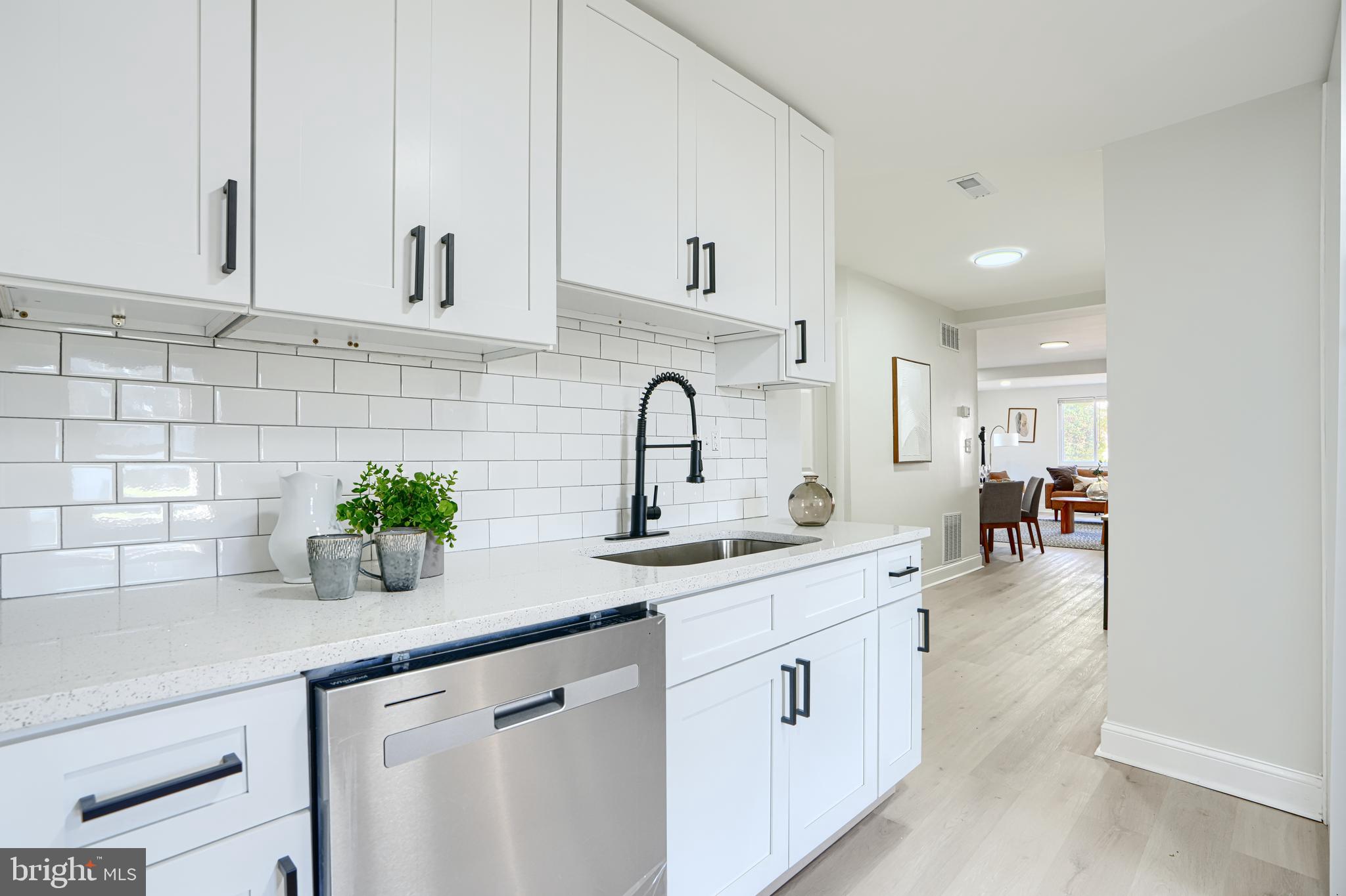 212 North Marlyn Avenue Essex, MD 21221 - Photo 20 of 54 a kitchen with sink a potted plant and cabinets