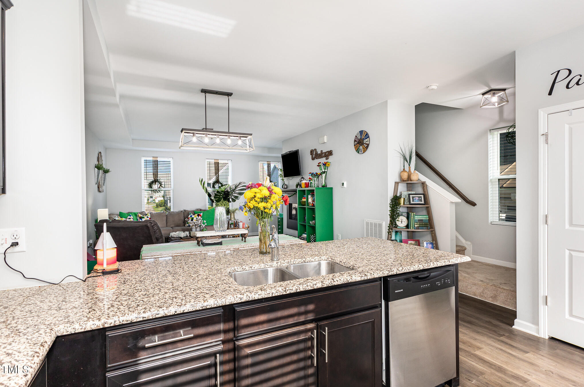 217 Jones Hill Road Holly Springs, NC 27540 - Photo 12 of 39 a kitchen with kitchen island granite countertop a sink a counter top space and living room view