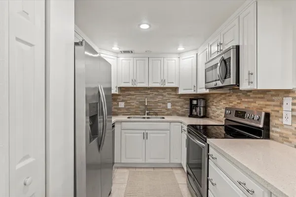 a kitchen with white cabinets and a stove