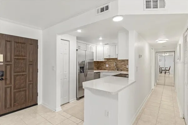 a kitchen with a table chairs refrigerator and microwave