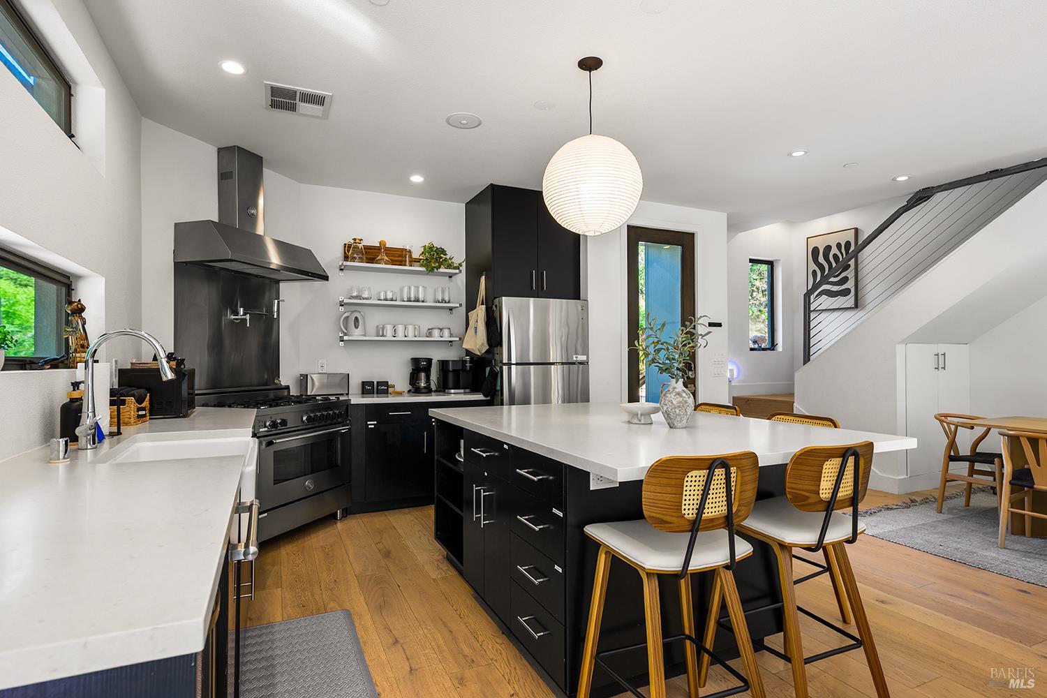 2563 Mill Creek Road Healdsburg, CA 95448 - Photo 15 of 42 a kitchen with stainless steel appliances kitchen island granite countertop a table chairs and a stove