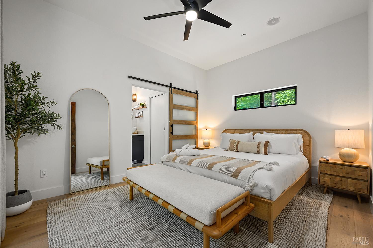 2563 Mill Creek Road Healdsburg, CA 95448 - Photo 6 of 42 a spacious bedroom with a bed and a chandelier