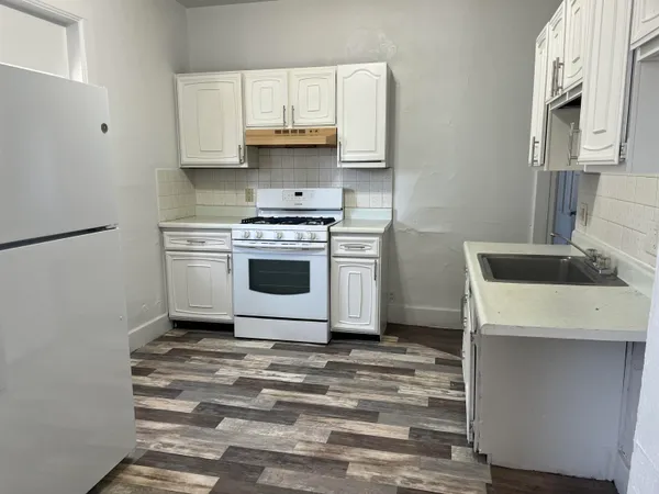 a kitchen with a sink a stove and cabinets