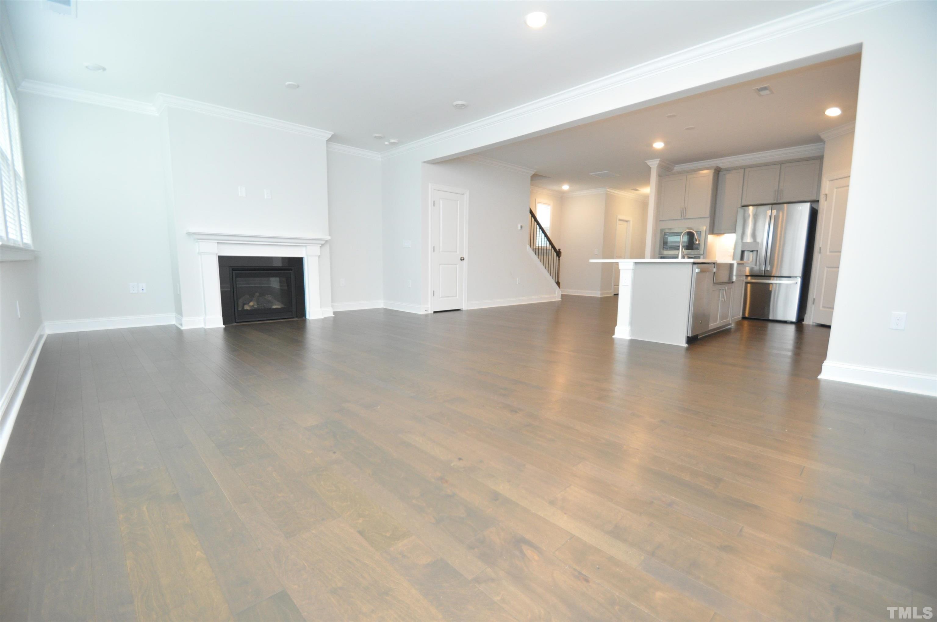 2949 Rise And Shine Road Apex, NC 27523 - Photo 13 of 49 a view of a kitchen and an empty room with wooden floor