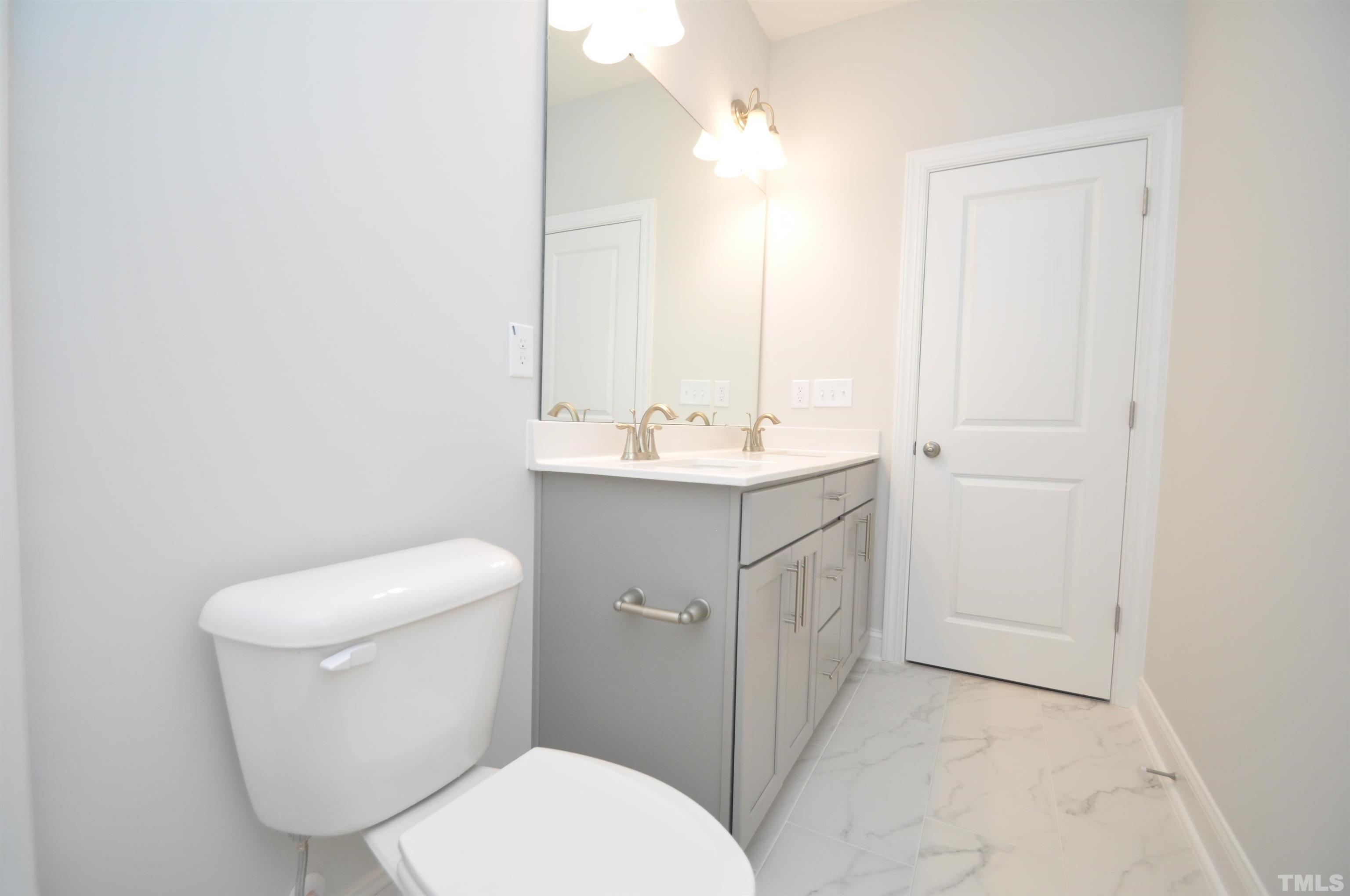 2949 Rise And Shine Road Apex, NC 27523 - Photo 22 of 49 a bathroom with a toilet sink and mirror