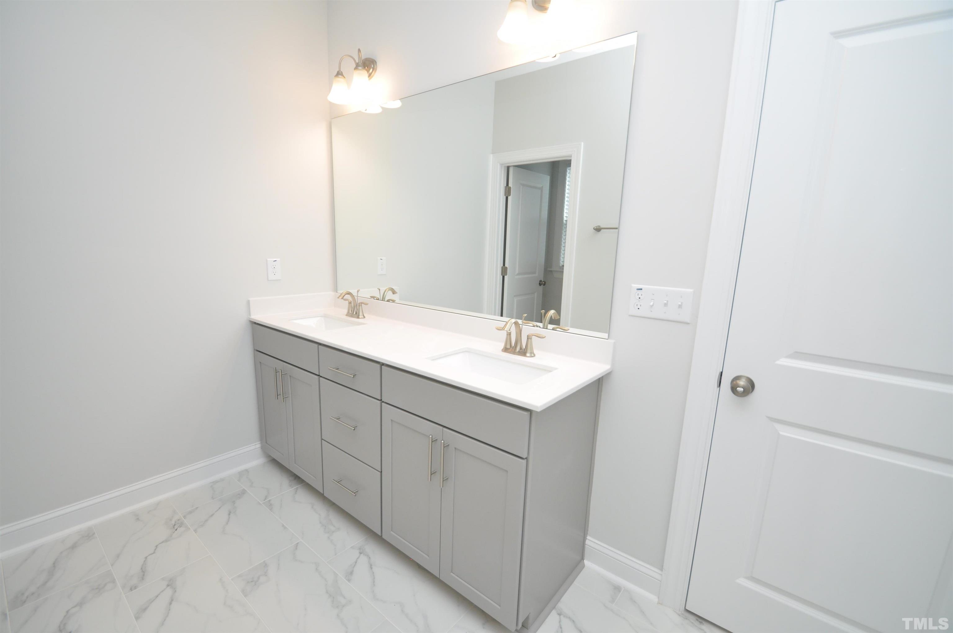 2949 Rise And Shine Road Apex, NC 27523 - Photo 32 of 49 a bathroom with a sink and mirror