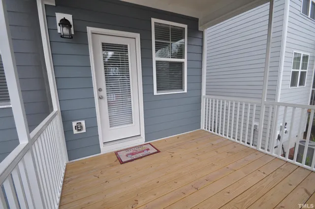 a view of two house with wooden deck and a table