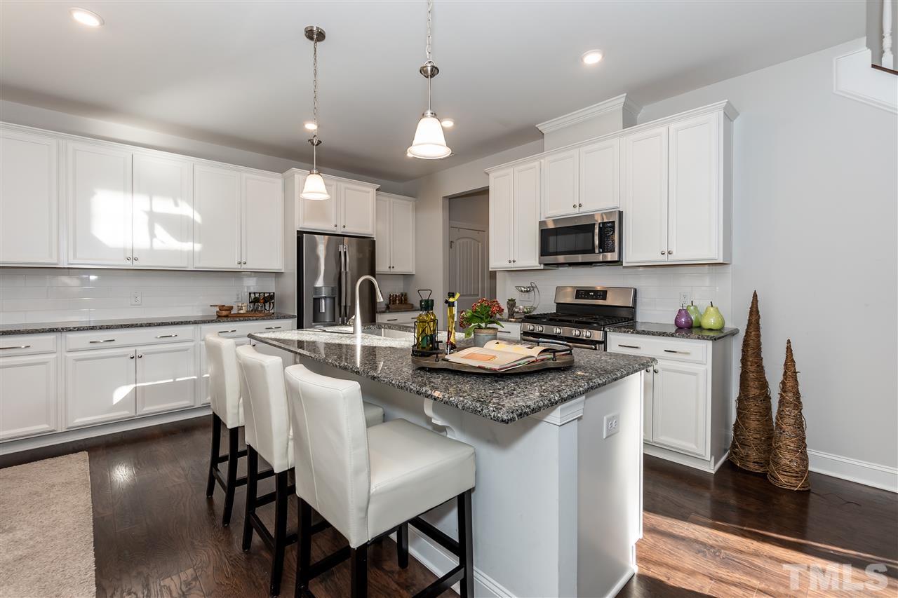 3 Moss Side Terrace Durham, NC 27703 - Photo 12 of 30 a kitchen with kitchen island granite countertop a sink a microwave a center island and cabinets