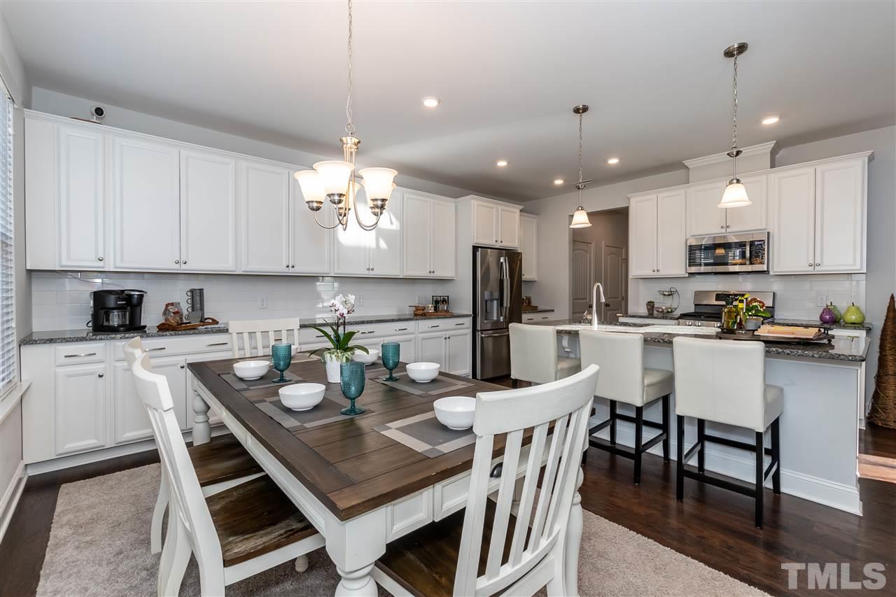 3 Moss Side Terrace Durham, NC 27703 - Photo 13 of 30 a kitchen with stainless steel appliances kitchen island granite countertop a dining table chairs and microwave