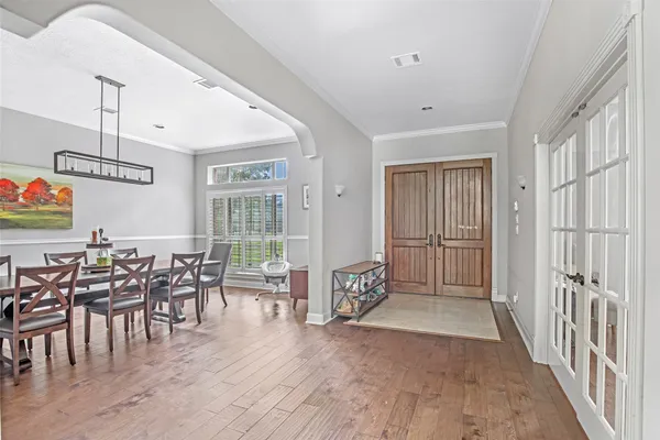 a living room with furniture a chandelier and a dining table