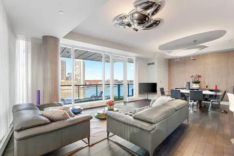 a living room with furniture kitchen view and a chandelier