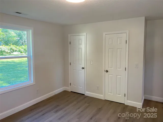 a view of a small space with wooden floor and a window