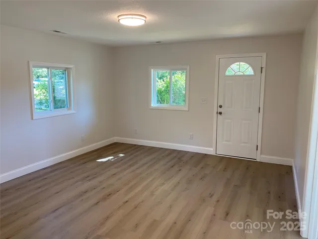 a view of empty room with wooden floor
