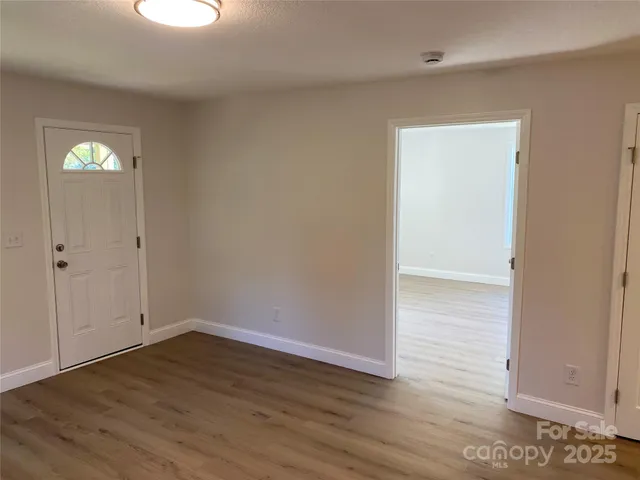 a view of a room that has wooden floor and windows