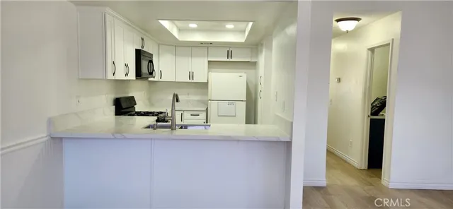 a kitchen with white cabinets and refrigerator