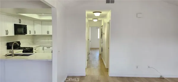 an empty room with wooden floor ceiling fan and windows